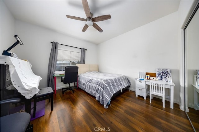 bedroom with dark hardwood / wood-style flooring, a closet, and ceiling fan