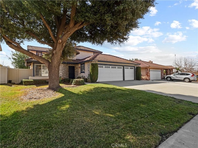 view of front of house with a garage, concrete driveway, a tile roof, fence, and a front yard