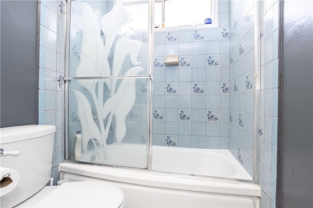 bathroom featuring enclosed tub / shower combo and toilet