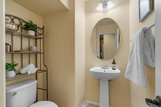 bathroom with toilet and a chandelier