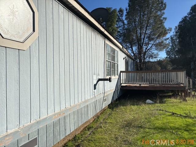 view of home's exterior featuring a wooden deck and a lawn