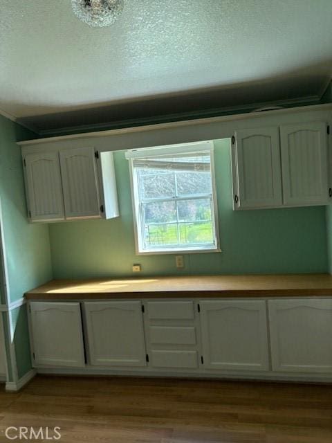 1845 Spring Valley Rd, Clearlake Oaks, CA 95423 - kitchen featuring wood finished floors, light countertops, a textured ceiling, and white cabinetry