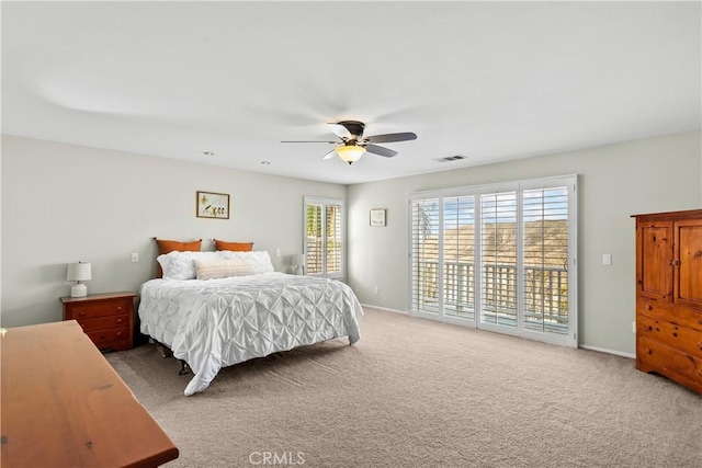 carpeted bedroom featuring ceiling fan, multiple windows, and access to exterior