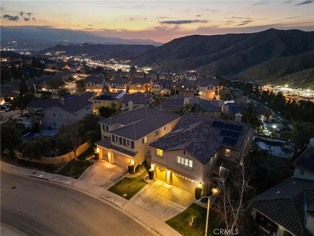 aerial view at dusk featuring a mountain view