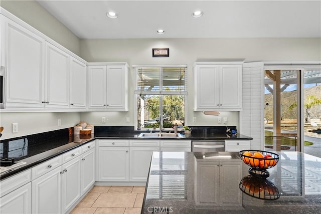 kitchen with white cabinetry, dark stone countertops, sink, and dishwasher