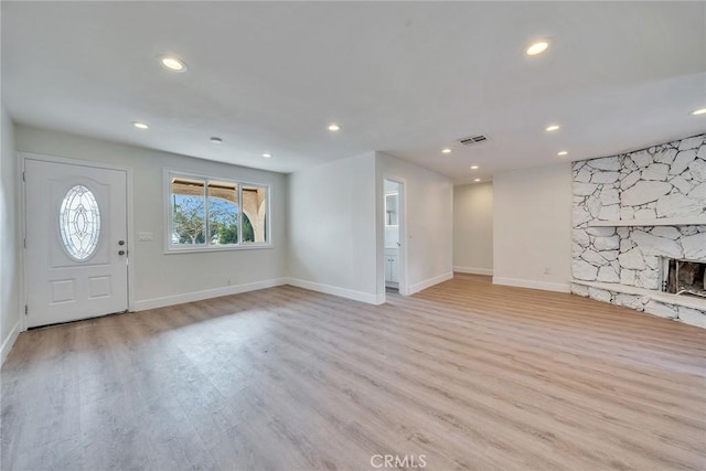 unfurnished living room featuring a fireplace and light hardwood / wood-style floors