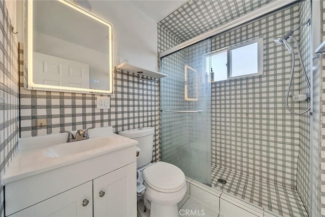 bathroom featuring vanity, a shower with shower door, and toilet