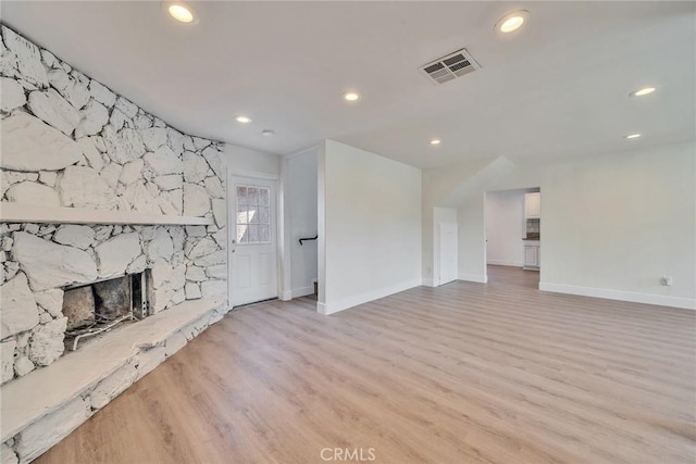 unfurnished living room featuring a fireplace and light hardwood / wood-style flooring