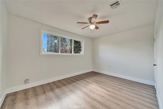 empty room with ceiling fan and light hardwood / wood-style flooring