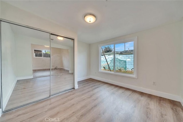 unfurnished bedroom featuring light hardwood / wood-style floors and a closet