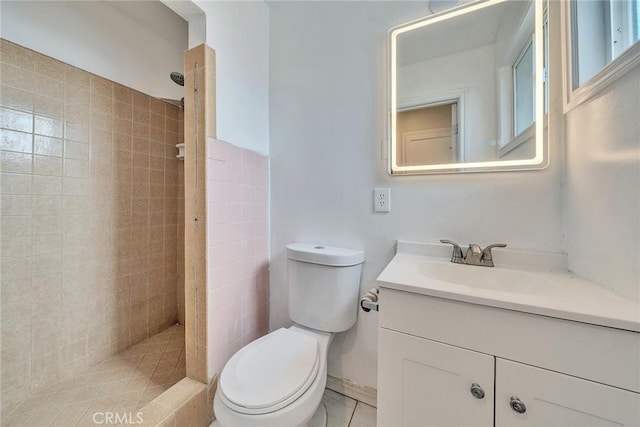 bathroom with vanity, toilet, and tiled shower