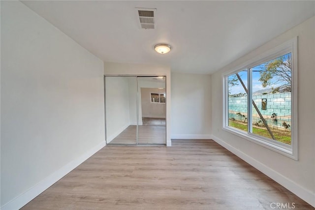 unfurnished room with light hardwood / wood-style flooring and a barn door