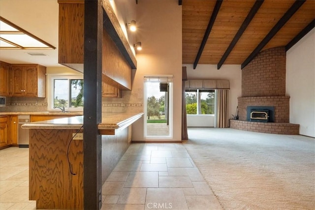 kitchen featuring light carpet, open floor plan, light countertops, backsplash, and brown cabinets