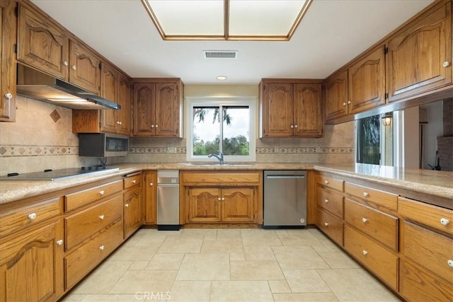 kitchen with light countertops, brown cabinets, and stainless steel appliances