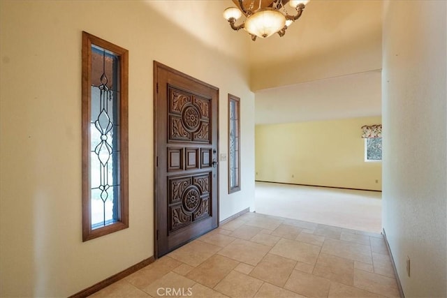 entryway featuring an inviting chandelier and baseboards