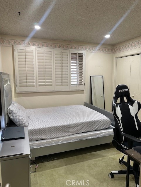 carpeted bedroom featuring a closet and a textured ceiling