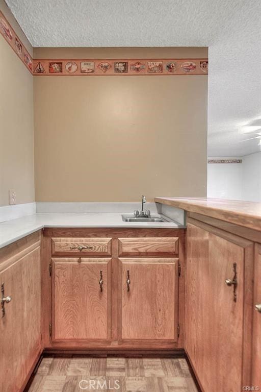 interior space with sink, light parquet flooring, and a textured ceiling