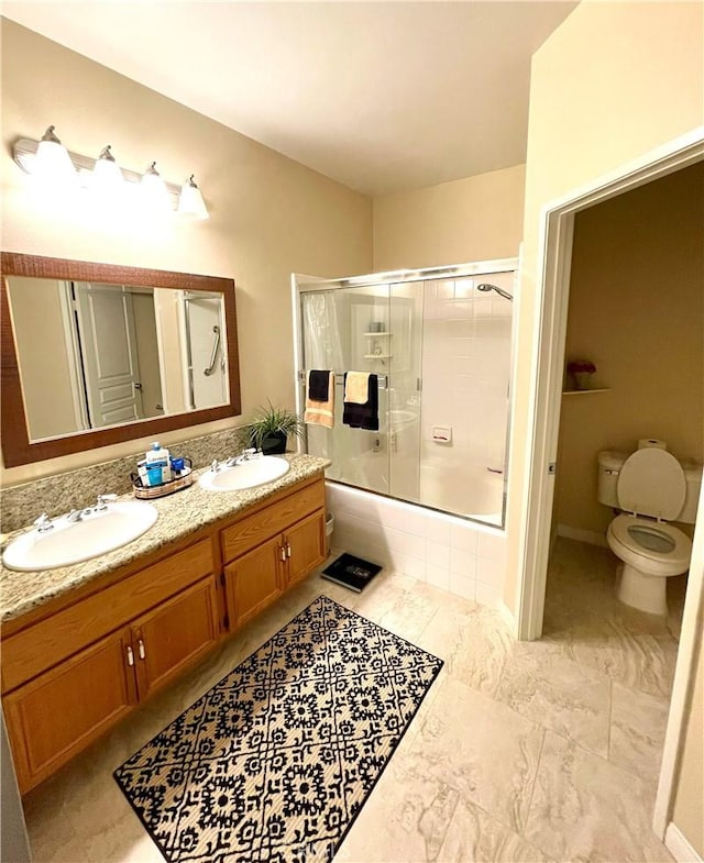 full bathroom featuring vanity, toilet, and combined bath / shower with glass door