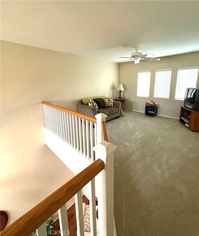 carpeted living room with ceiling fan