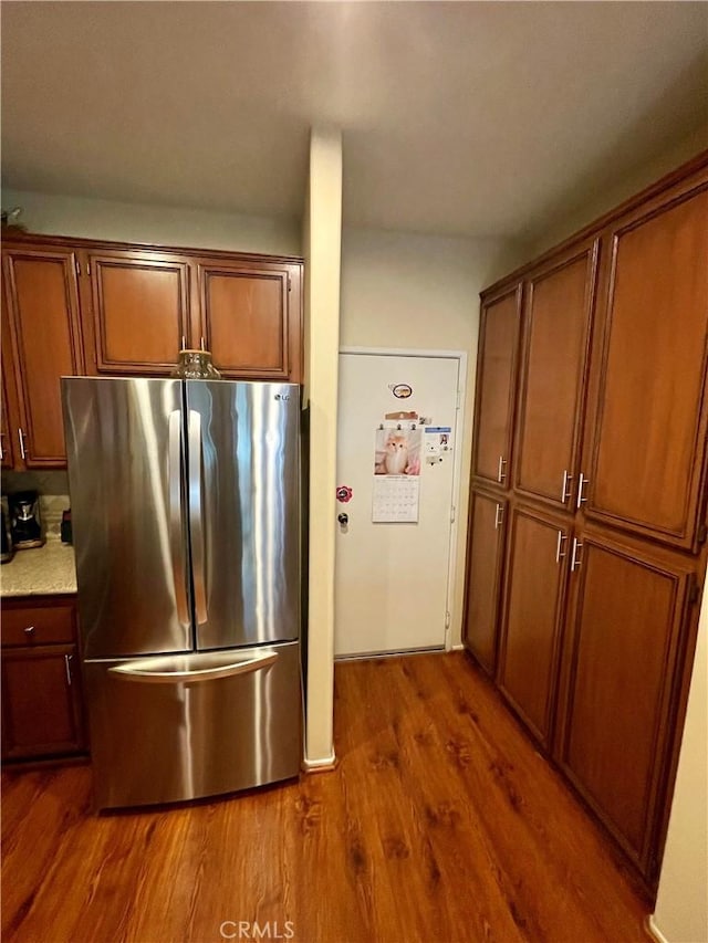 kitchen with wood-type flooring and stainless steel fridge