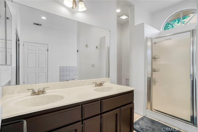 bathroom with vanity and a shower with door