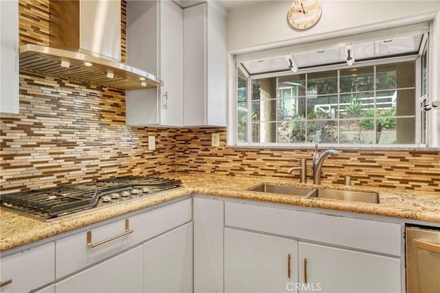 kitchen featuring stainless steel appliances, white cabinetry, sink, and wall chimney range hood