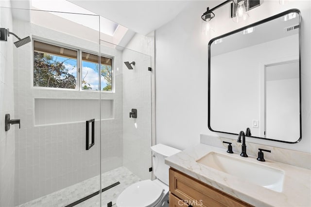 bathroom featuring vanity, walk in shower, and toilet