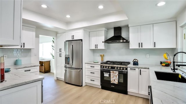 kitchen with white cabinetry, stainless steel fridge with ice dispenser, high end black range, and wall chimney exhaust hood