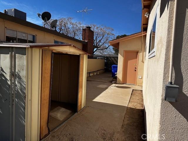 view of property exterior featuring central AC and a shed