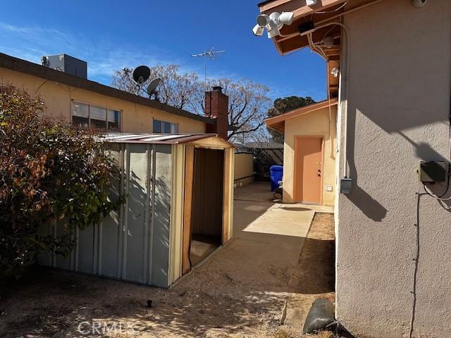 view of side of property featuring a storage unit