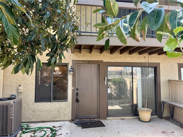 doorway to property featuring central AC unit and a patio area