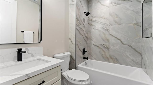 full bathroom featuring vanity, tiled shower / bath combo, and toilet