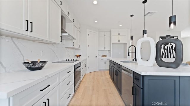 kitchen with white cabinetry, stainless steel appliances, decorative light fixtures, and sink