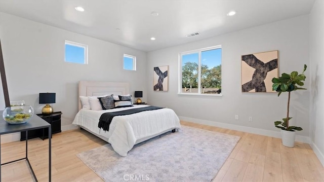 bedroom with multiple windows and light hardwood / wood-style floors