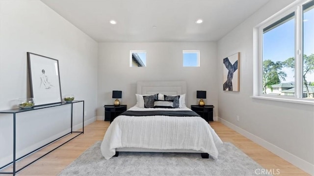 bedroom with multiple windows and light hardwood / wood-style flooring