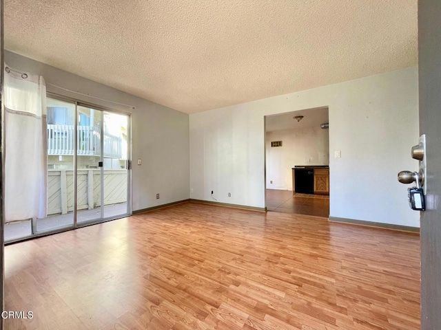 spare room with light hardwood / wood-style flooring and a textured ceiling