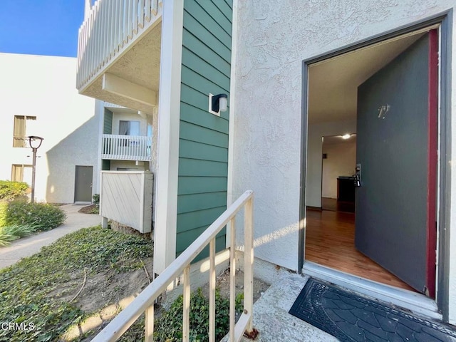 view of exterior entry with a balcony