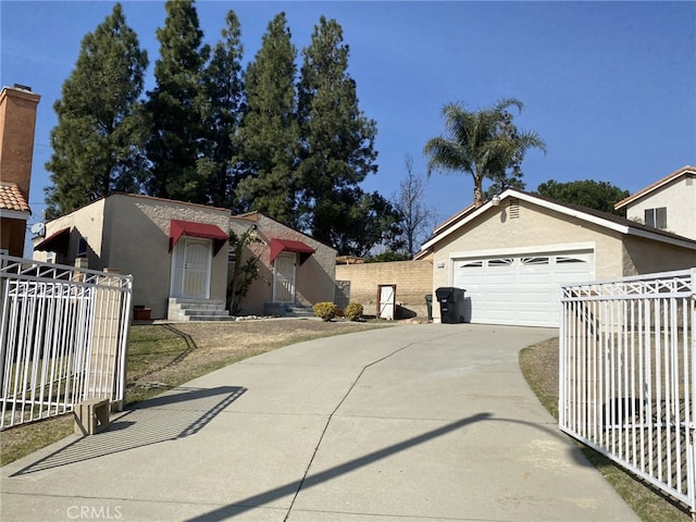 view of front of house with concrete driveway, an attached garage, fence, and stucco siding