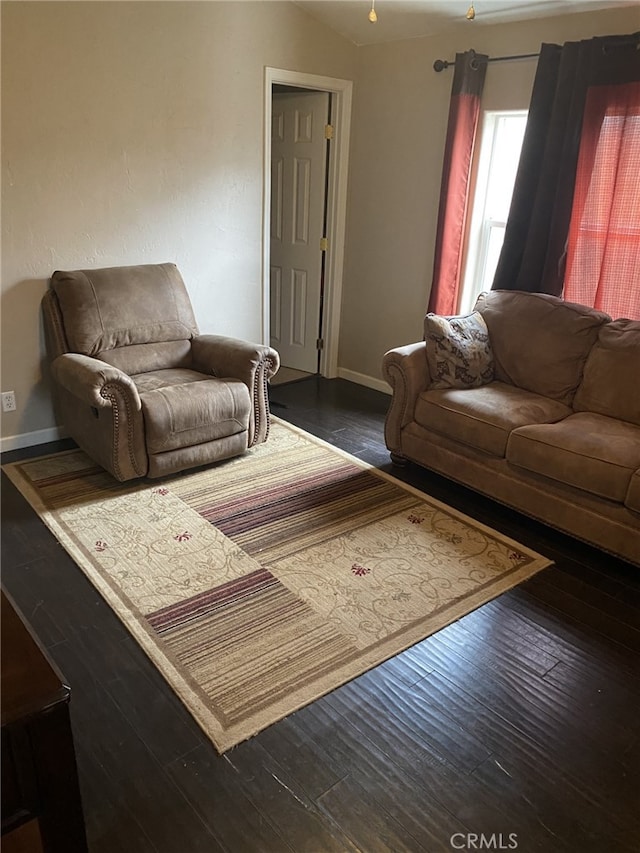 living room featuring baseboards, vaulted ceiling, and wood finished floors