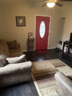 living room with a ceiling fan, baseboards, and wood finished floors