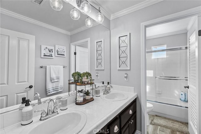 full bathroom featuring toilet, wood-type flooring, ornamental molding, vanity, and enclosed tub / shower combo