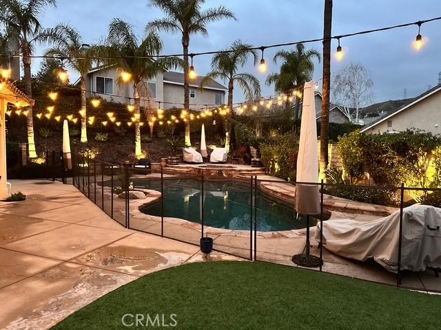 pool at dusk featuring a patio