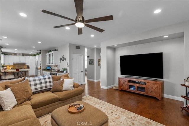 living room with ceiling fan and dark hardwood / wood-style flooring