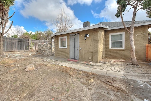 back of property featuring a patio, brick siding, and fence