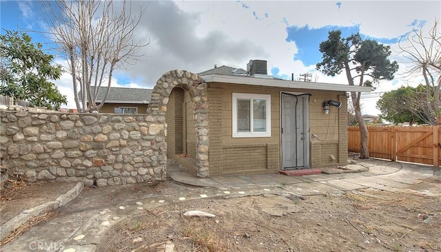 view of outbuilding with fence and cooling unit