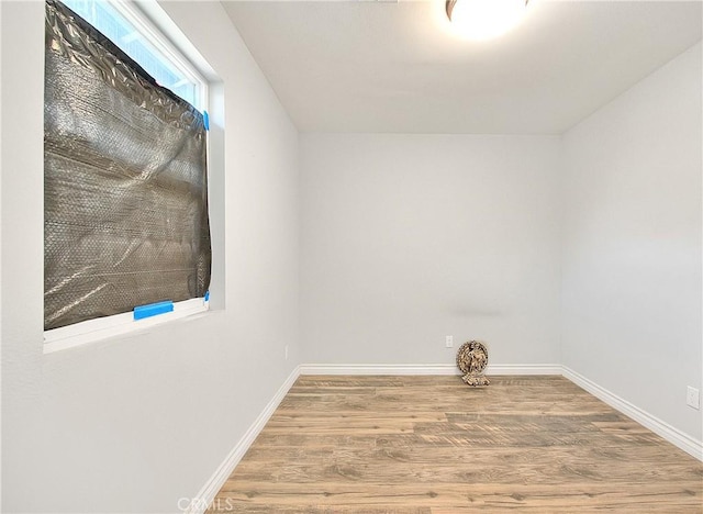 unfurnished room with wood finished floors and baseboards