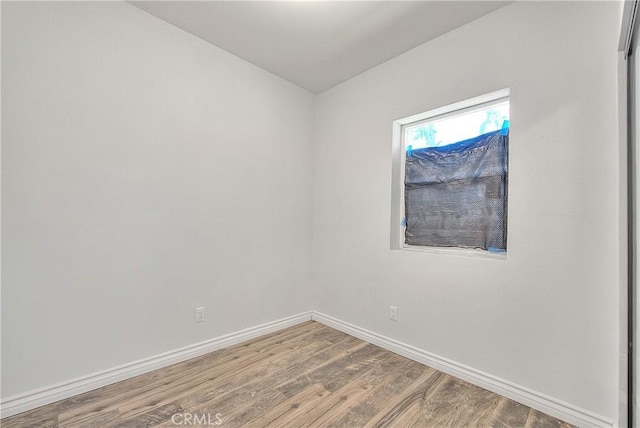 empty room with wood finished floors and baseboards