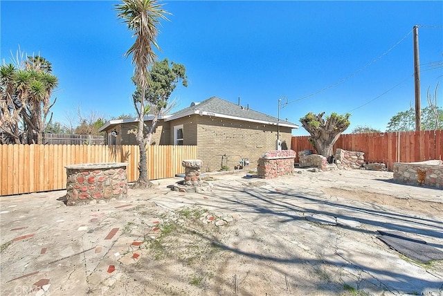 back of property featuring fence and brick siding