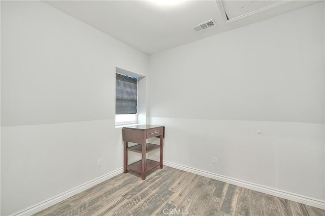unfurnished room with visible vents, wood finished floors, and baseboards