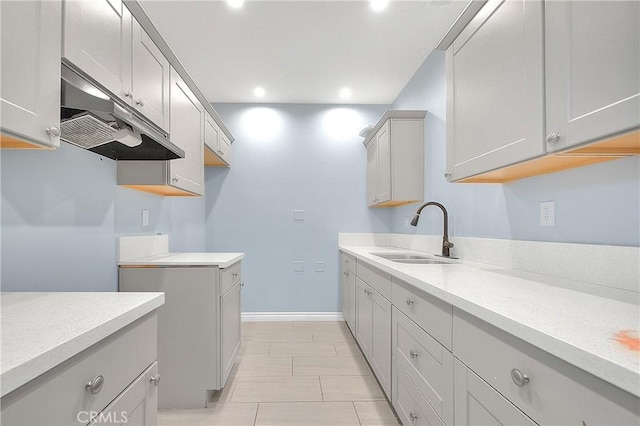clothes washing area with recessed lighting, light tile patterned floors, baseboards, and a sink